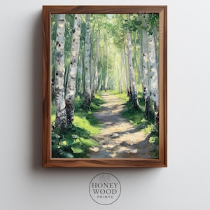 Puede incluir: Pintura enmarcada de un sendero forestal soleado. Altos abedules con corteza blanca y hojas verdes bordean el camino, creando una sensación de profundidad. La obra de arte está en un marco de madera, con el texto "HONEY WOOD PRINTS" en la parte inferior.