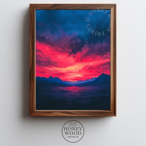 Puede incluir: Una impresión artística enmarcada que representa una puesta de sol dramática sobre un lago y montañas. El cielo es una mezcla de tonos azul profundo y rojo vivo. El texto "HONEY WOOD PRINTS" está presente en la parte superior derecha e inferior.
