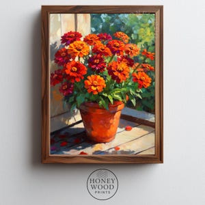May include: A framed print of a vibrant floral arrangement. The artwork features a terracotta pot overflowing with orange and red zinnias. The painting is set against a backdrop of a window and wooden deck, with the Honey Wood Prints logo at the bottom.