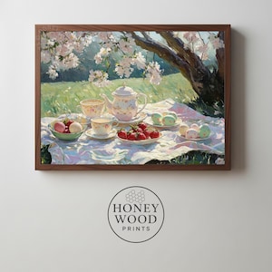 Könnte beinhalten: Ein gerahmter Druck einer Picknick-Szene unter einem blühenden Baum. Ein weißes Tischtuch zeigt eine Teekanne, Teetassen, Erdbeeren und Macarons. Das Kunstwerk ist ein Produkt von Honey Wood Prints.