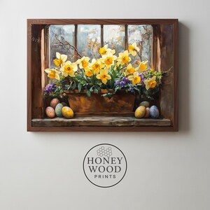 May include: A framed print of a window scene with a terracotta planter overflowing with yellow daffodils and purple flowers. Painted Easter eggs are on the windowsill. The frame is dark brown.