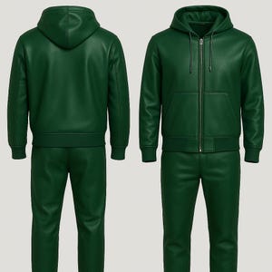 Può includere: Una tuta in pelle verde composta da due pezzi. La giacca ha un cappuccio, una cerniera frontale e una tasca anteriore. I pantaloni sono a gamba dritta. La tuta è mostrata da davanti e da dietro.