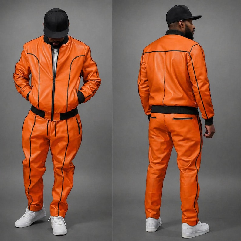 May include: Orange leather tracksuit with black trim. The jacket has a zip-up front and the pants have pockets. The outfit is paired with a black baseball cap and white sneakers. The tracksuit is shown from the front and back.