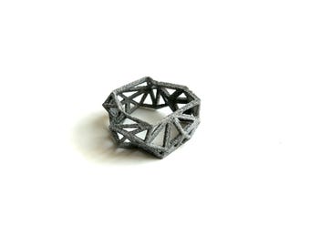 May include: A silver-colored geometric ring with a triangular design.