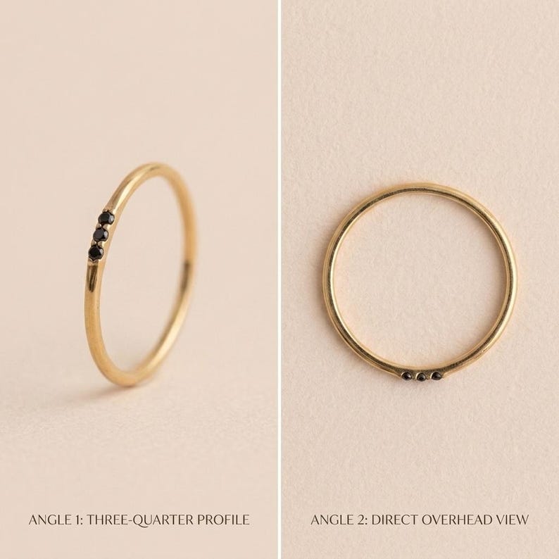 Op de afbeelding: Een dunne gouden ring met drie kleine, ronde, zwarte stenen op een rij. De afbeelding toont de ring vanuit twee perspectieven: een driekwart profielweergave en een direct bovenaanzicht, wat de delicate metalen constructie benadrukt.