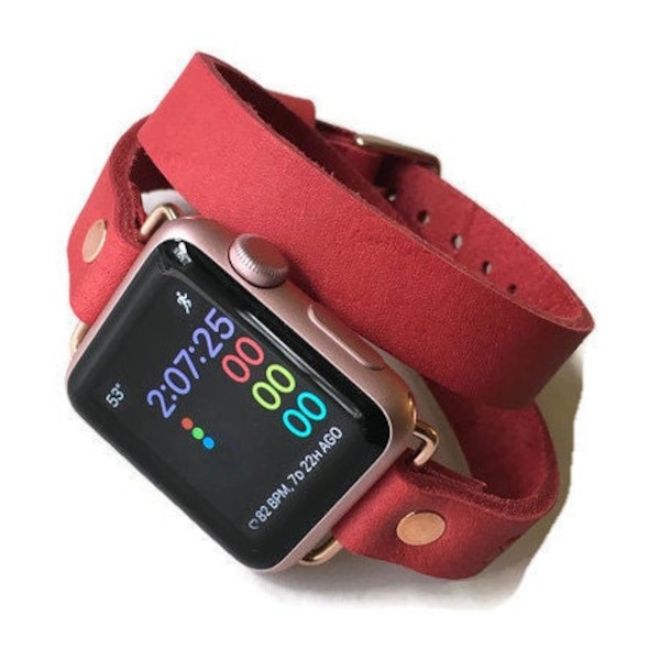 Puede incluir: Una banda de doble vuelta de cuero rojo para un Apple Watch. La esfera del reloj muestra la hora, la frecuencia cardíaca y el tiempo transcurrido desde el último entrenamiento. 