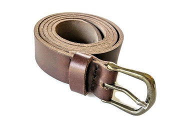 May include: A rolled-up brown leather belt with a brass-colored buckle. The belt is a medium brown color and appears to be made of high-quality leather. The buckle is a classic design.