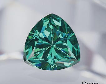 May include: A faceted, triangular gemstone in shades of green. The gem has a complex, symmetrical pattern of internal reflections. The word "Green" is displayed in the bottom right corner.