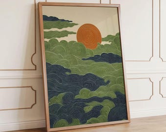 May include: Framed art print featuring an abstract landscape. The artwork depicts a stylized orange sun setting over rolling green and navy blue clouds. The print is encased in a light brown wooden frame, leaning against a white wall and wooden floor.