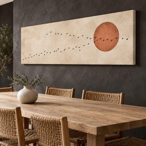 May include: A long rectangular canvas wall art piece featuring a textured beige background with a large, solid terracotta-colored circle on the right side and a flock of small black birds flying in a diagonal formation across the center.