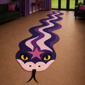 Puede incluir: Una alfombra larga y sinuosa con forma de serpiente que presenta un patrón ondulado en morado oscuro y rosa claro. La cabeza de la serpiente tiene ojos amarillos, una estrella rosa en la frente, un hocico rosa claro con dos orificios nasales negros y una lengua negra bífida.