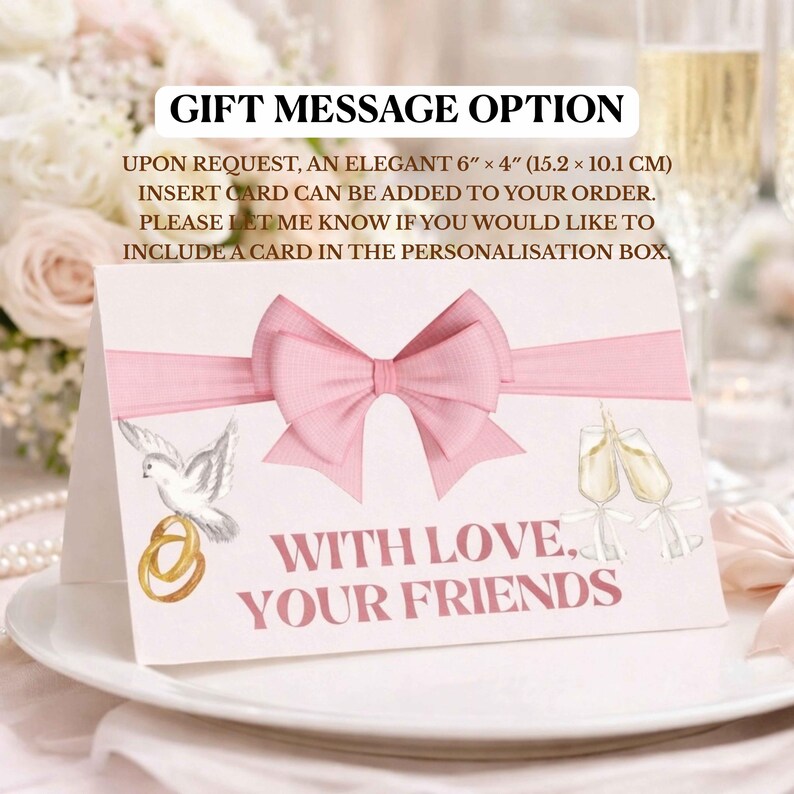 Pode incluir: Cart&atilde;o branco com la&ccedil;o e fita rosa, apresentando uma pomba com alian&ccedil;as e ta&ccedil;as de champanhe. O texto "WITH LOVE, YOUR FRIENDS" &eacute; exibido. O cart&atilde;o mede 15,2 cm x 10,1 cm.
