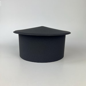 May include: A black, cylindrical hat with a triangular top. The hat has a wide brim and a textured surface. The hat is made of a soft material and is likely a costume or fashion accessory.