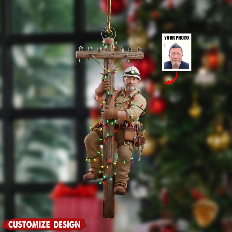 Puede incluir: Adorno navide&ntilde;o que representa a un liniero trepando a un poste de electricidad de madera adornado con luces de colores. El adorno incluye un espacio para una foto, etiquetado como "YOUR PHOTO", y el texto "CUSTOMIZE DESIGN".
