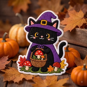 May include: An embroidered patch featuring a black cat wearing a purple witch hat and cape. The cat holds a brown basket filled with red and white mushrooms. Additional mushrooms and orange autumn leaves are at the base of the cat figure.