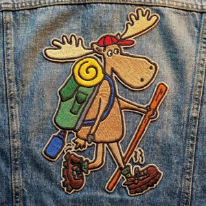 May include: A white ceramic mug with a black handle and the text "But First, Coffee" in a black, handwritten-style font. The mug is on a white surface.