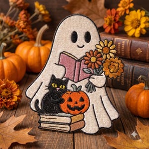 May include: An embroidered patch featuring a light beige ghost holding a pink open book and a bouquet of orange and yellow flowers. A black cat sits on a stack of two books next to a small orange jack-o'-lantern with a carved face.