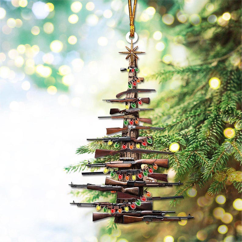 K&ouml;nnte beinhalten: Weihnachtsbaumschmuck in Form eines Baumes, der aus verschiedenen Gewehren besteht. Der Baum ist mit bunten Lichterketten geschm&uuml;ckt und mit einem goldenen Stern gekr&ouml;nt. Der Schmuck h&auml;ngt an einer goldenen Schnur.