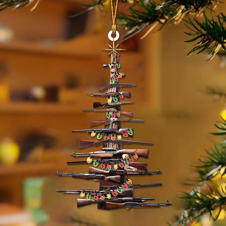 K&ouml;nnte beinhalten: Ein Weihnachtsbaumschmuck in Form eines Baumes aus Gewehren. Die braunen und schwarzen Gewehre sind dreieckig angeordnet und mit bunten Weihnachtslichtern geschm&uuml;ckt. Der Schmuck h&auml;ngt an einem goldenen Faden.