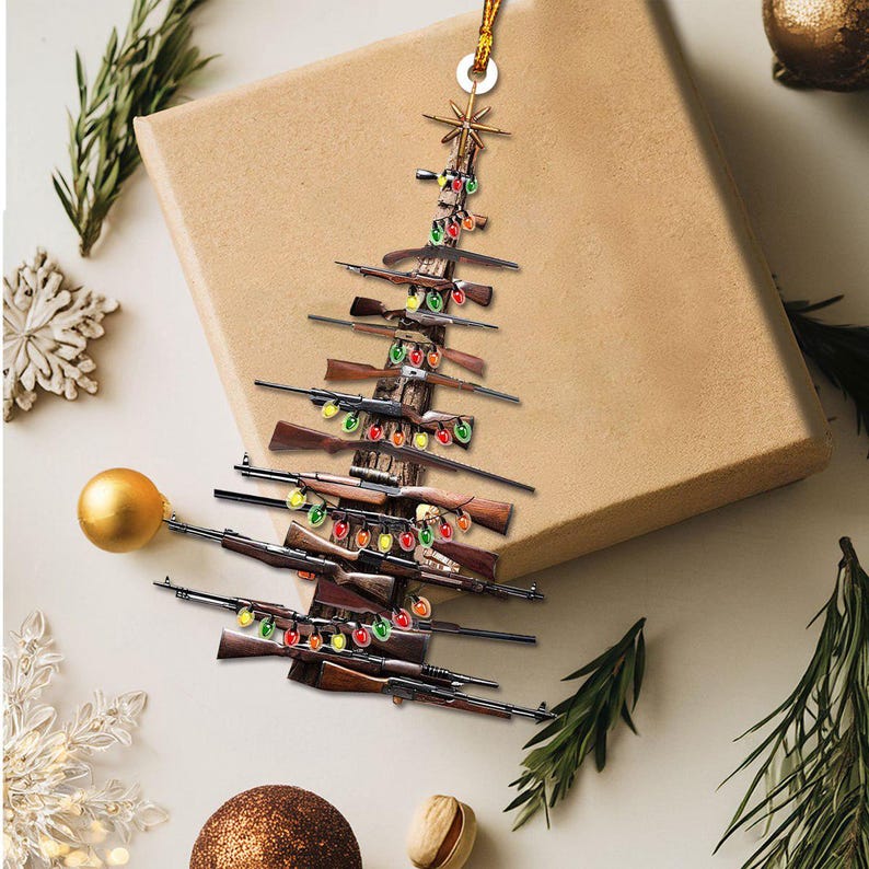 K&ouml;nnte beinhalten: Ein Weihnachtsbaumschmuck aus Gewehren, verziert mit bunten Lichterketten. Der Baum wird von einem goldenen Faden gehalten, und ein Stern kr&ouml;nt den Baum. Der Schmuck befindet sich vor einem neutralen Hintergrund mit Weihnachtsdekorationen.