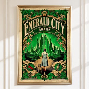 May include: A framed art print with a vintage design. The artwork features a girl in a blue dress walking towards a green city, with the words "EMERALD CITY AWAITS" at the top. The print has a gold frame and a green and gold border.
