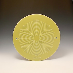 May include: A yellow circular template with a grid pattern and numbers 34568, 48, 36, 8, 5, 6, and 9 printed on it. The template has a small hole on the right side and the text "Mach Tools" printed on the bottom.