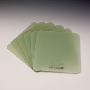 May include: A stack of eight translucent green square sheets of material with the text "Resin Tech" printed on the bottom sheet.