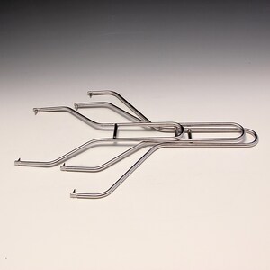 May include: A stainless steel barbecue grill grate lifter. The tool has a series of curved arms with angled tips, connected to a handle. The lifter is designed to lift and move hot grill grates safely.