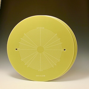 May include: A set of three yellow circular plastic templates with concentric circles and numbers printed on them. The numbers on the template are 34568, 468, 48, 5, 6, 8, and 36. The text "Hirian ElaK" is printed on the bottom of the template.