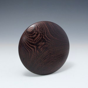May include: A dark brown wooden bowl with a swirling grain pattern.