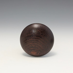May include: A dark brown wooden sphere with a smooth, polished surface and a wood grain pattern.