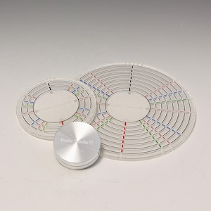 Può includere: Tre modelli circolari trasparenti in acrilico con anelli concentrici e linee colorate, insieme a un piccolo cilindro metallico argentato. I modelli hanno segni neri, rossi, verdi e blu. Il cilindro ha il testo "Hain Tools".