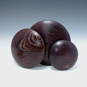 May include: Three wooden bowls of varying sizes, all with a dark brown wood grain pattern.