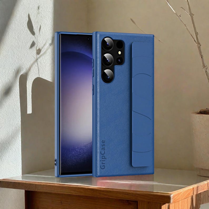 May include: A blue smartphone case with a textured finish and a cardholder on the back. The case is open, revealing the phone's screen. The brand name "GripCase" is printed vertically on the case.