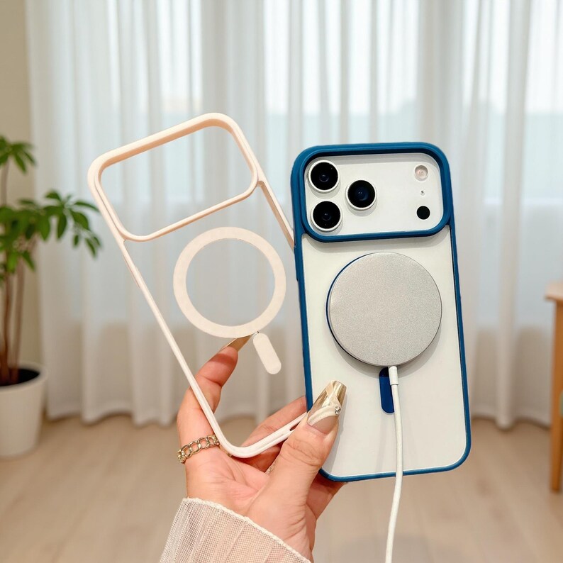 Puede incluir: Una funda transparente para tel&eacute;fono con un marco rosa claro y un dise&ntilde;o de c&iacute;rculo blanco. Una funda de tel&eacute;fono blanca y azul con un c&iacute;rculo plateado y un cable blanco. La funda tiene un borde azul.