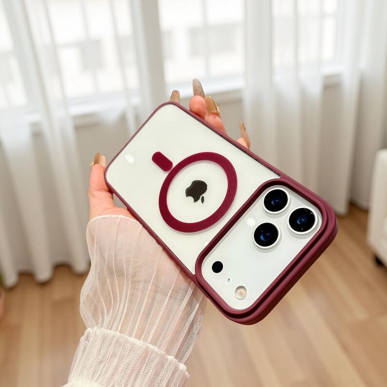 Puede incluir: Una funda transparente para tel&eacute;fono con un borde burdeos y un dise&ntilde;o circular burdeos. La funda tiene un interior blanco y un recorte para la c&aacute;mara del tel&eacute;fono.