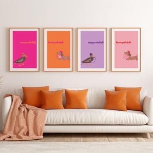 K&ouml;nnte beinhalten: Vier gerahmte Kunstdrucke mit Dackel-Illustrationen auf farbenfrohen Hintergr&uuml;nden. Die Hintergr&uuml;nde sind pink, orange, lila und hellrosa. Die Bilder h&auml;ngen &uuml;ber einem wei&szlig;en Sofa mit orangefarbenen Kissen und einer Decke.