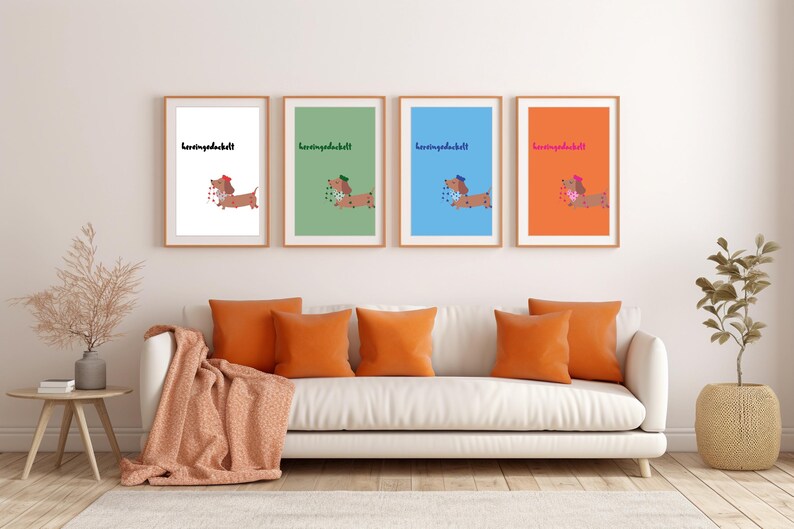 K&ouml;nnte beinhalten: Vier gerahmte Kunstdrucke mit Dackel-Illustrationen und dem Text "herzensdackel". Sie h&auml;ngen &uuml;ber einem wei&szlig;en Sofa mit orangefarbenen Kissen und einer Decke. Links befindet sich ein Beistelltisch mit Dekoration.