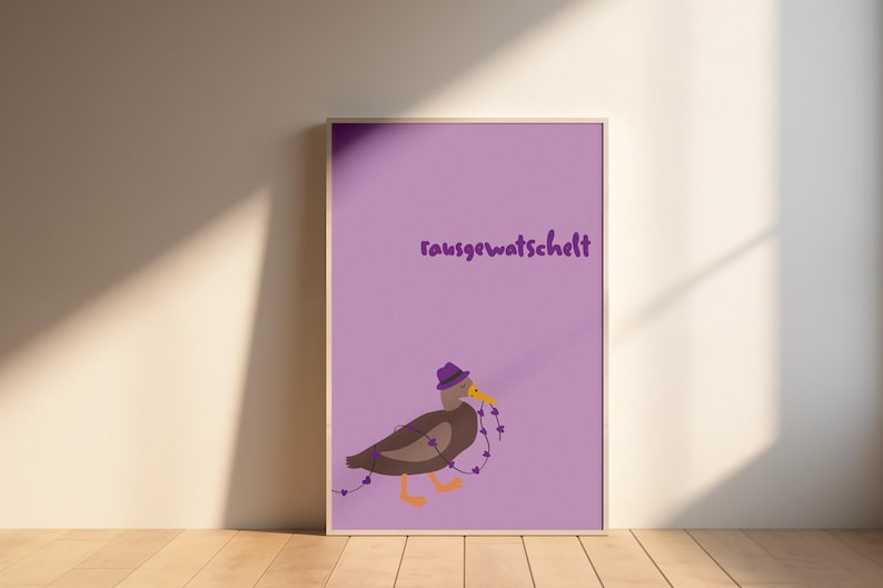 K&ouml;nnte beinhalten: Ein gerahmter Druck mit lila Hintergrund und dem deutschen Text "rausgewatschelt". Der Druck zeigt eine Cartoon-Ente mit lila Hut, die eine Kette aus lila Herzen h&auml;lt. Die Ente hat braune Federn und orangefarbene F&uuml;&szlig;e.