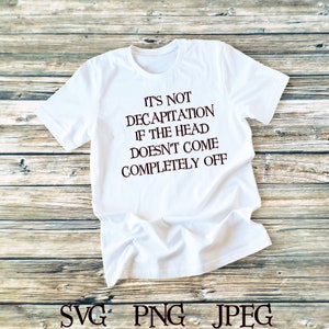Puede incluir: Camiseta blanca con el texto "It's not decapitation if the head doesn't come completely off" impreso en marrón en la parte delantera.