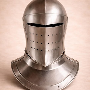 May include: A polished steel knight's helmet. The helmet has a rounded top, eye slit, and ventilation holes. It includes a neck guard. The metal has a reflective surface. The helmet is designed to protect the head and neck.