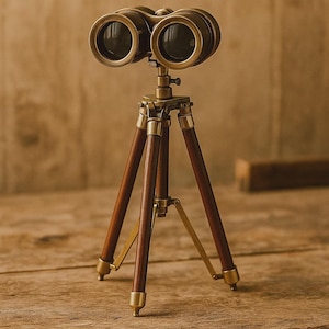 Pode incluir: Um telescópio em miniatura de latão e madeira sobre um tripé. Os binóculos têm um acabamento castanho escuro com detalhes em latão. As pernas do tripé são de madeira escura com pés de latão.