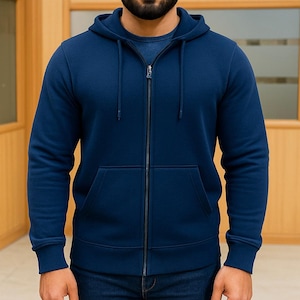 May include: A navy blue zip-up hoodie with a drawstring hood and a front kangaroo pocket. The hoodie has a full-length zipper and ribbed cuffs and hem. The model is wearing blue jeans.
