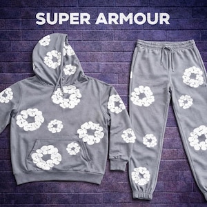 May include: A gray hoodie and matching sweatpants set. Both pieces feature a white floral pattern. The hoodie has a drawstring hood and a front pocket. The text "SUPER ARMOUR" is at the top of the image.