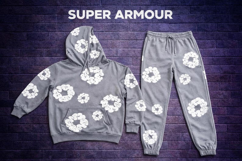 May include: A gray hoodie and matching sweatpants set. Both pieces feature a white floral pattern. The hoodie has a drawstring hood and a front pocket. The text "SUPER ARMOUR" is at the top of the image.