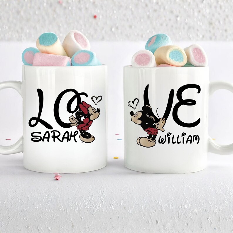 Pu&ograve; includere: Due tazze in ceramica bianca con scritta nera "LOVE" e illustrazioni di Topolino. Una tazza dice "SARAH" e l'altra "WILLIAM". Ogni tazza &egrave; piena di marshmallow colorati.