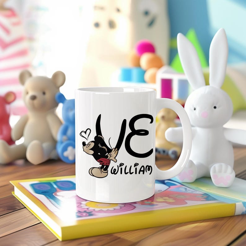 Pu&ograve; includere: Tazza in ceramica bianca con un design di Topolino, la parola "LOVE" e il nome "WILLIAM". La tazza &egrave; circondata da giocattoli, tra cui un coniglietto bianco e orsacchiotti. La tazza ha un manico.