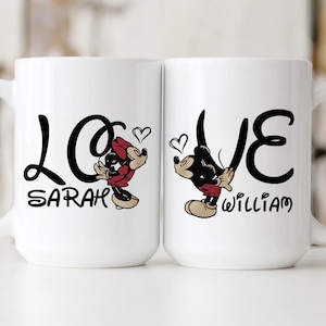 Pu&ograve; includere: Due tazze in ceramica bianca con testo nero e illustrazioni di cartoni animati. Una tazza presenta Minnie Mouse, la parola "LOVE" e il nome "Sarah". L'altra tazza ha Topolino, la parola "LOVE" e il nome "William". Entrambe le tazze hanno grafiche a forma di cuore.