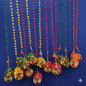 Può includere: Ghirlanda di perline colorate con ornamenti decorativi sospesi. La ghirlanda presenta fili di perline verdi, gialle, rosa e arancioni. Gli ornamenti sono in colori coordinati con dettagli dorati e nappe.