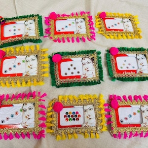 Può includere: Nove cornici decorative con bordi colorati e dettagli con nappe. Ogni cornice presenta un ritratto di donna e un motivo decorativo. Le cornici sono in vari colori, tra cui verde, giallo e rosa.